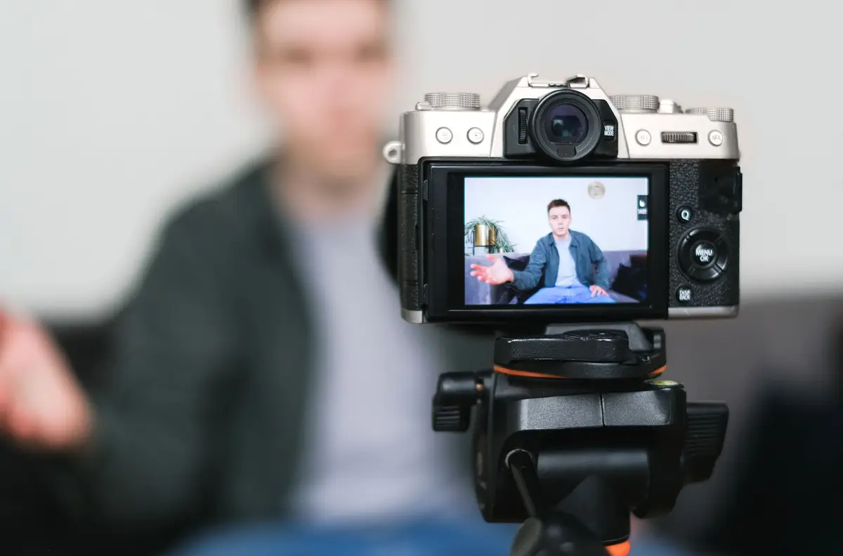 Homem gravando vídeo com câmera em tripé